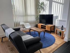 uma sala de estar com um sofá e uma televisão em Delightful & Spacious Flat in London - Peckham em Londres