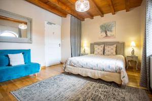 a bedroom with a bed and a blue couch at Domaine du Cuiset -Gîte des Combles in Saint-André-sur-Vieux-Jonc