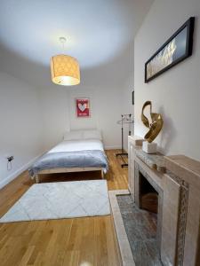 a bedroom with a bed and a fireplace at LA CASITA in Colindale