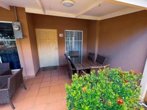 eine Veranda mit einem Tisch und Stühlen sowie einer gelben Tür in der Unterkunft Villa Paraíso Coco 20, near to beach, town & pool in Herradura