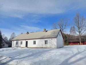 a white house sitting in the snow in a yard at Paganamaa puhkemaja ja peosaal in Liguri