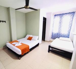 a bedroom with two beds and a ceiling fan at Laurel plaza in Montería