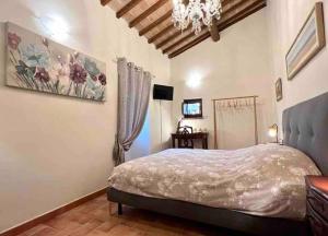 1 dormitorio con cama y lámpara de araña en La Casina di Nada, en Massa Martana