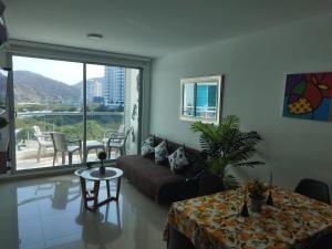 un soggiorno con divano e tavolo di Hermoso y cómodo apartamento Rodadero Sur (Santa Marta) a Santa Marta