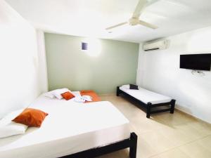 a bedroom with two beds and a flat screen tv at Laurel plaza in Montería