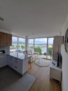 a kitchen and living room with a view of the ocean at Apartamentos Puerto Camariñas in Camariñas