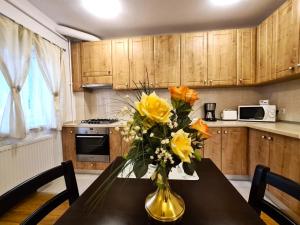 eine Vase gelber Blumen auf einem Tisch in der Küche in der Unterkunft Apartament Giulio in Sibiu