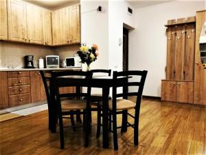 a black dining room table with chairs and a vase of flowers at Apartament Giulio in Sibiu