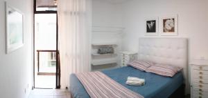 1 dormitorio con 1 cama con edredón azul en Apartamento charmoso em frente a praia em Cabo Frio en Cabo Frío