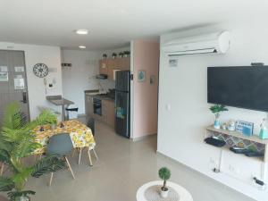un soggiorno con tavolo e cucina di Hermoso y cómodo apartamento Rodadero Sur (Santa Marta) a Santa Marta