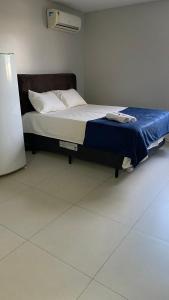 a bedroom with a bed with a blue blanket on it at Flat Mobiliado em excelente localização in Campina Grande