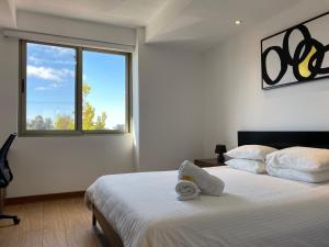 1 dormitorio con 2 camas y ventana grande en Apartamentos La Cañada, en Guatemala