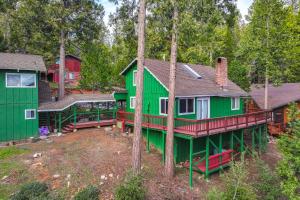 a green and red house in the woods at Cozy Mi-Wuk Village Cabin 18 Mi to Dodge Ridge! in Mi-Wuk Village