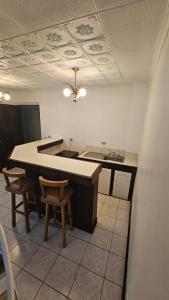 a kitchen with a large island in a room with chairs at Hotel Valladolid in Heredia