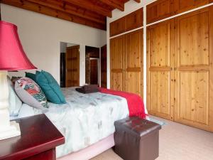 a bedroom with a bed with a red lamp and wooden cabinets at Lilly’s-place in Sabie