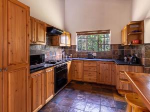 a large kitchen with wooden cabinets and black appliances at Lilly’s-place in Sabie