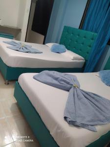 2 camas en una habitación de color azul en HOTEL VILLA CAMPESTRE Aventureros, en San Gil
