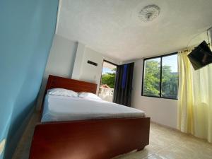a bedroom with a bed and a window at HOTEL VILLA CAMPESTRE Aventureros in San Gil