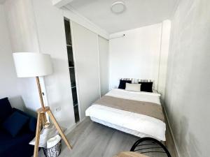 Dormitorio pequeño con cama y lámpara en Ocean Breeze Oasis in Puerto de la Cruz en Puerto de la Cruz