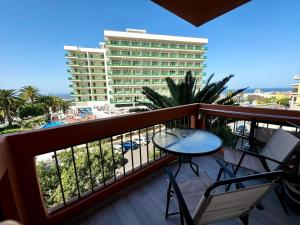 un balcón con mesa y sillas y un edificio en Ocean Breeze Oasis in Puerto de la Cruz, en Puerto de la Cruz