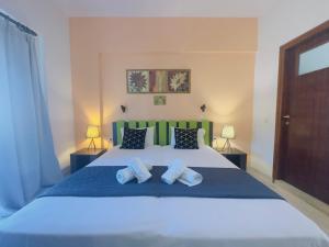 a bedroom with a large bed with two pillows at Marina Studios in Sidari