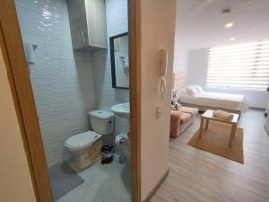 a bathroom with a toilet and a living room at Apartamento de Estudio en Bogotá, Casco central in Bogotá