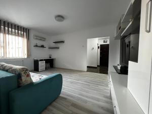 sala de estar con sofá azul y cocina en Apartament Teo Ultracentral en Piteşti
