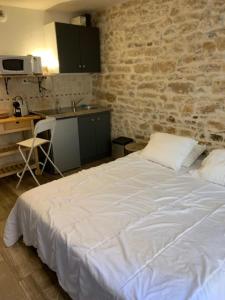 a white bed in a room with a kitchen at Studio Georges cosy 2 pers Vieux Lyon in Lyon