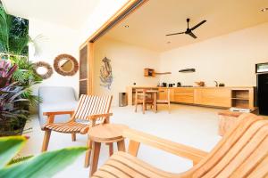 an open living room with chairs and a kitchen at Casa Borka in Puerto Escondido