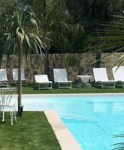 a group of lounge chairs and a swimming pool at Villa laura in Palermo