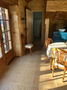 a room with a table and chairs and a room with a door at A l'Orée des Vignes in Sauveterre-la-Lémance