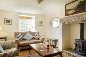 uma sala de estar com um sofá e um fogão a lenha em White Lodge Haughton Castle em Hexham