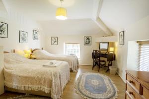 a bedroom with two beds and a table at White Lodge Haughton Castle in Hexham