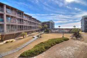 an exterior view of a resort building with a beach at Tilghman Beach & Racquet Club - 114 in Myrtle Beach
