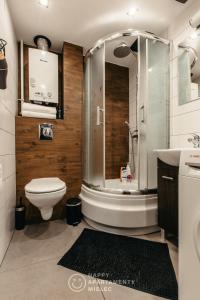 een badkamer met een douche, een toilet en een wastafel bij Happy Day - Happy Apartamenty Mielec in Mielec