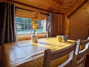 a dining room table with a yellow polka dot table cloth at The Hive - Unique log cabin with wood burning stove in Ludchurch