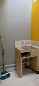 Habitación con escritorio de madera y lavabo. en Apartaestudio amoblado, en Piendamó