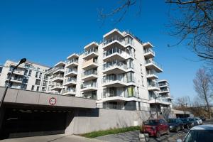 Un gran edificio blanco con coches aparcados delante. en Apartament nad Wisłą, bezpłatny parking, AWG APARTMENTS, en Cracovia