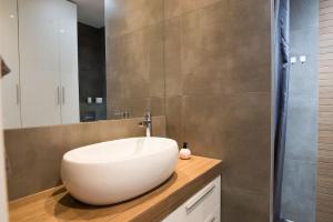 Un baño con un lavabo blanco sobre una encimera. en Apartament nad Wisłą, bezpłatny parking, AWG APARTMENTS, en Cracovia 34 fotos más