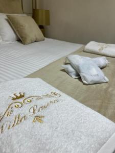 duas camas com cobertores brancos e toalhas em Villa laura em Palermo