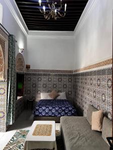 een slaapkamer met een bed en een bank bij Riad Palais D'Or in Rabat