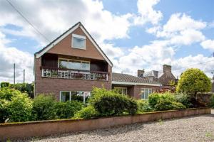 a brick house with a balcony on the side of it at The Old Stables - Hot Tub, Sauna and Cinema in Alyth