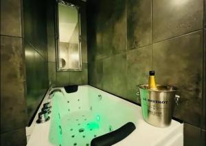 a bathroom with a tub with a bottle in a bucket at Orphelin studio avec Balnéo proche centre ville in Reims