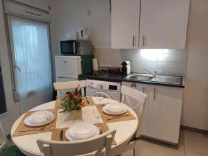 una cucina con tavolo e sedie e una cucina con lavandino di Super F2 à 5mn aéroport d'Orly a Paray-Vieille-Poste
