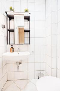 a bathroom with a sink and a mirror at bee Apartments Design NESPRESSO Küche Parkplätze PS5 in Aachen