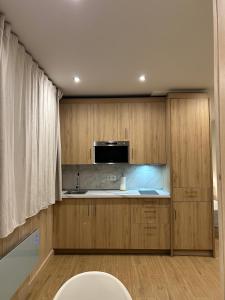 a kitchen with wooden cabinets and a sink at Primavera Premium Sierra Nevada 4 in Sierra Nevada