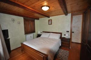 a bedroom with a bed and a wooden ceiling at Cat Marvei in Villadossola