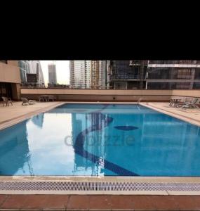 a large blue swimming pool in a building at Paz Holiday Luxurious Space in Dubai