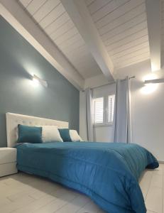 a bedroom with a blue bed and a window at R & D in Alghero
