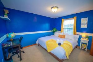 Dormitorio azul con cama y escritorio en Cute Artsy7 Getaway, large parking, 20mins to OSU, en Albany
